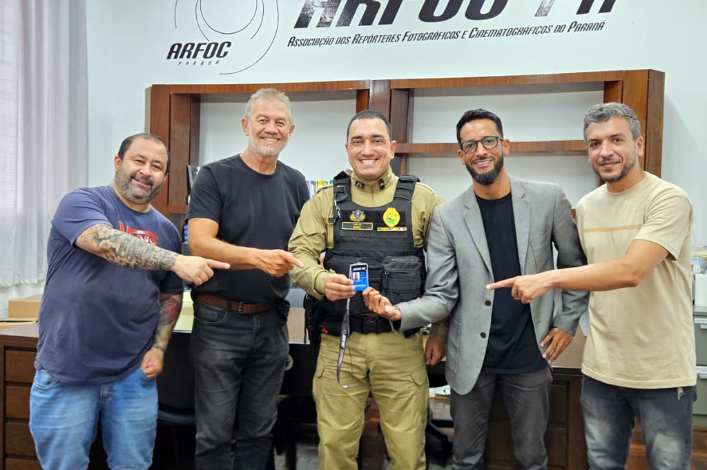 Entrega da credencial ARFOC Paraná 2026 ao Cabo QP PM Mauro Berg do Prado Junior, integrante do Centro de Comunicação Social da Polícia Militar do Paraná (PMPR), durante encontro institucional realizado em Curitiba.